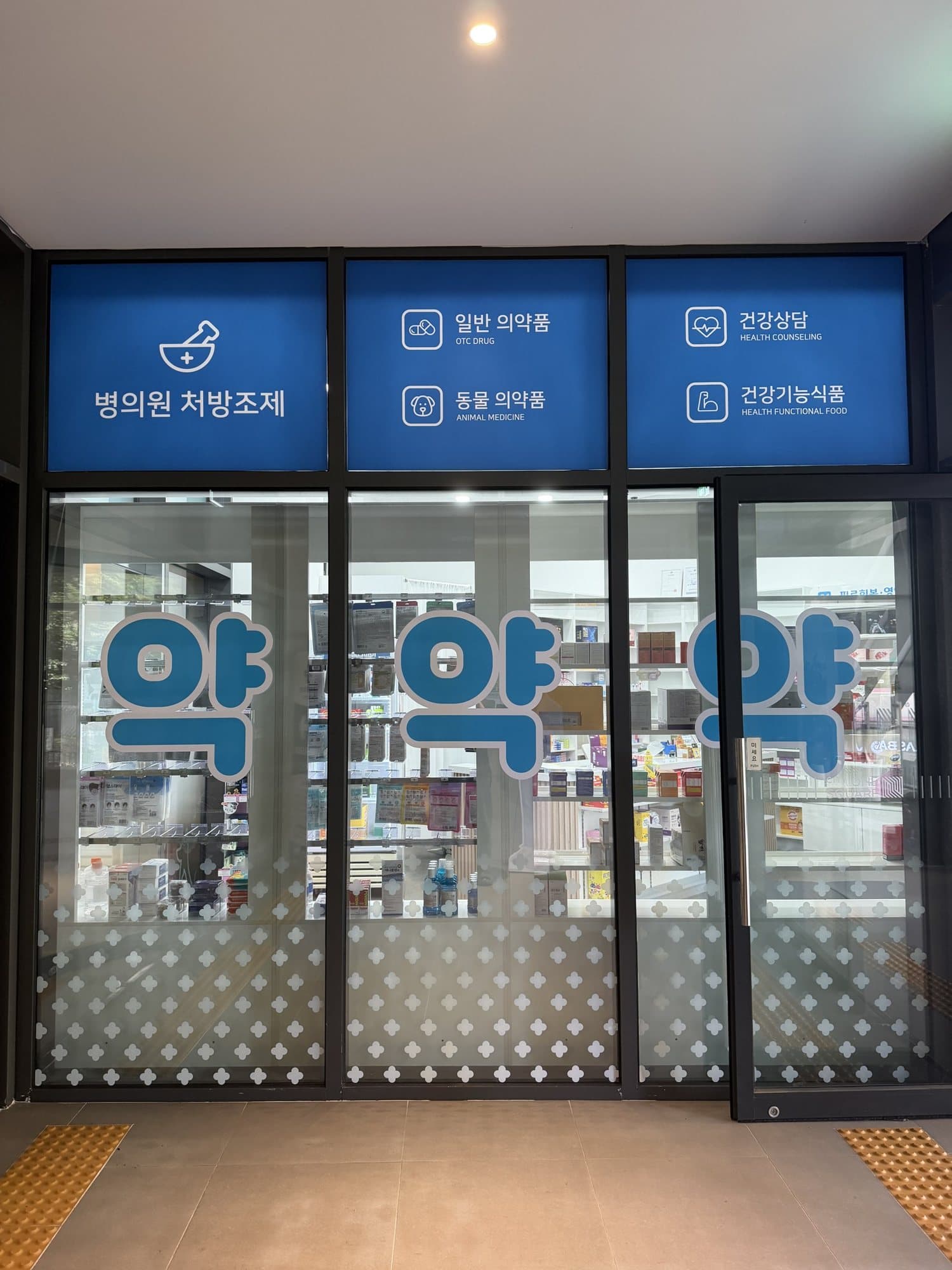 출입구 유리에 붙은 병의원 처방조제·일반의약품·건강기능식품 안내